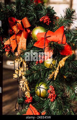 Weihnachtsschmuck und Christbaumzweige am Zaun auf der Straße Stockfoto