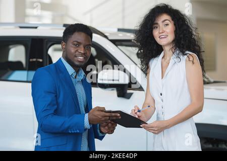 Afroamerikanischer Händler und Kunde unterzeichnen Vereinbarung im Salon Stockfoto
