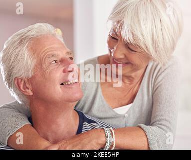 Es gibt so viele Gründe, dich zu lieben. Ein glückliches Seniorenpaar zu Hause. Stockfoto