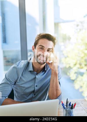 Gewidmet dem Job. Ein hübscher junger Geschäftsmann im Büro. Stockfoto