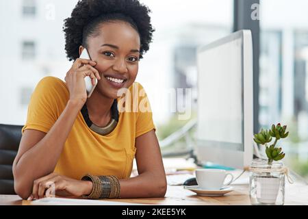 Shes freut sich immer, von ihren Kunden zu hören. Zugeschnittenes Porträt einer jungen Designerin, die in ihrem Büro auf ihrem Handy spricht. Stockfoto