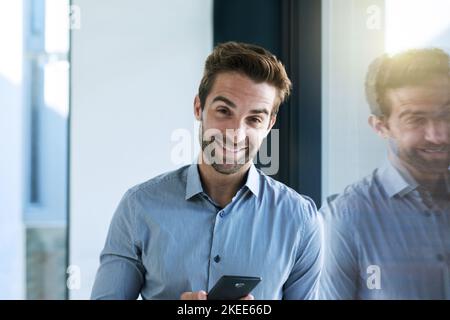 Gewidmet dem Job. Ein hübscher junger Geschäftsmann im Büro. Stockfoto