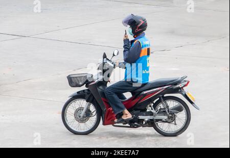 SAMUT PRAKAN, THAILAND, OCT 03 2022, Ein Taxifahrer fährt ein Motorrad und telefoniert Stockfoto