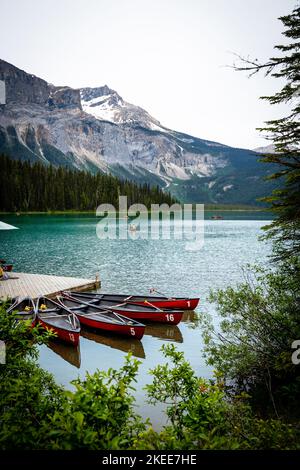 Eine Reihe leerer Kanus Reihen sich mitten im Sommer am Rand des Emerald Lake an Stockfoto