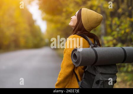 Weibliche Reisende genießen Atmosphäre zu Fuß entlang Herbst Straße Stockfoto