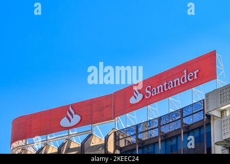 Alicante, Spanien - 29. Oktober 2022: Blick auf den oberen Teil eines Geschäftsgebäudes mit Schild und Logo. Auf dem Schild auf dem Gebäude steht: „Santander“ Stockfoto