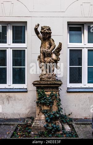 Skulptur des kleinen Kindes auf der Rückseite der Adler auf Sockel im Innenhof des Gebäudes in der Rankestrasse, Berlin Stockfoto
