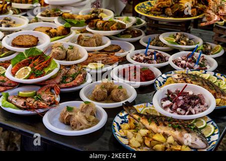 Verschiedene Fisch- und Meeresfrüchte-Gerichte zum Verkauf auf dem Capo Markt (Mercado del Capo), Palermo, Sizilien, Italien. Stockfoto