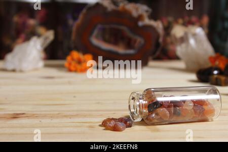 Agatisierte Koralle mit Quarzkristallen und Blumen auf Meditationsaltar Stockfoto