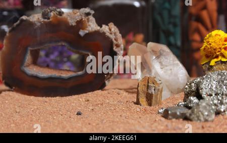 Gelbe Blume mit Pyritfelsen und Kristallen auf dem australischen roten Sand Stockfoto