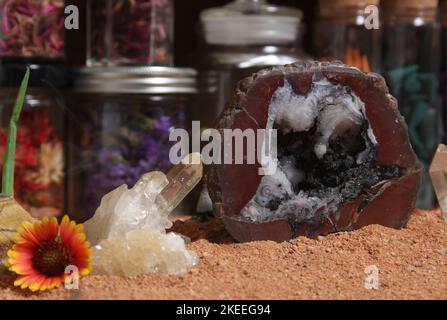 Chakra-Steine mit Aloe Vera und Blumen auf australischem rotem Sand Stockfoto