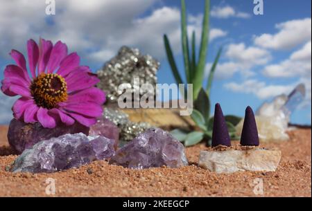 Chakra-Steine und Blumen auf australischem rotem Sand Stockfoto