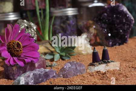 Amethyst-Kristalle und Chakra-Steine auf dem australischen roten Sand. Meditationstisch Stockfoto