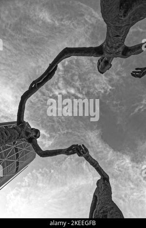 Eine Graustufenaufnahme der Skulptur der Familie des Mannes in Calgary, Kanada, unter einem bewölkten Himmel. Stockfoto