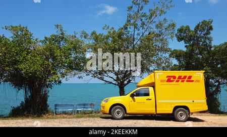 KOH CHANG, TRAT, THAILAND – 11. NOVEMBER 2022: DHL-LIEFERWAGEN. DHL ist weltweit Marktführer in der Logistikbranche. Das Auto ist am Strand. Der Fahrer ruht sich an sonnigen Tagen auf einer tropischen exotischen Insel aus Stockfoto