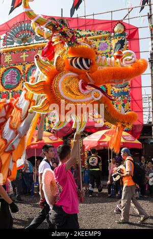 Dorfbewohner führen einen traditionellen, farbenfrohen Drachentanz auf dem zehnjährigen Da Jiu Festival-Gelände, kam Tin, New Territories, Hong Kong, 2015, auf Stockfoto