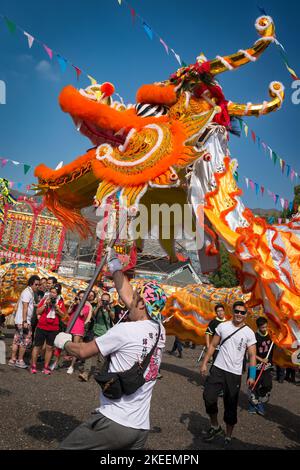 Dorfbewohner führen einen traditionellen, farbenfrohen Drachentanz auf dem zehnjährigen Da Jiu Festival-Gelände, kam Tin, New Territories, Hong Kong, 2015, auf Stockfoto