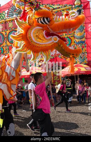 Dorfbewohner führen einen traditionellen, farbenfrohen Drachentanz auf dem zehnjährigen Da Jiu Festival-Gelände, kam Tin, New Territories, Hong Kong, 2015, auf Stockfoto