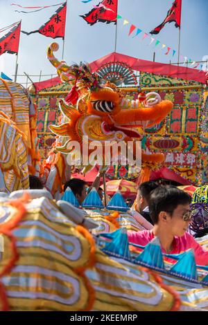 Dorfbewohner führen einen traditionellen, farbenfrohen Drachentanz auf dem zehnjährigen Da Jiu Festival-Gelände, kam Tin, New Territories, Hong Kong, 2015, auf Stockfoto