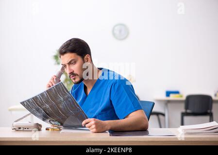 Junger Radiologe, der in der Klinik sitzt Stockfoto