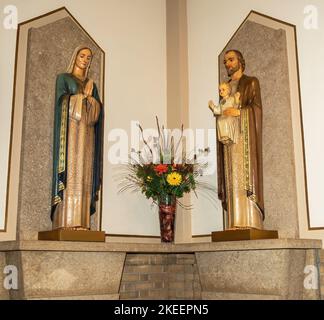 Statuen von Mary und St. Joseph mit dem Jesuskind und einem Blumenstrauß in St. Marias katholische Kirche in Winona, Minnesota, USA. Stockfoto