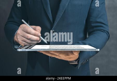Elektronische Signatur. Geschäftsmann, der mit einem neuen Geschäftsprojekt arbeitet. Mit modernem digitalen Tablet-pc. Unterzeichnet Pläne und analysiert sie. Geschäftsmann s Stockfoto