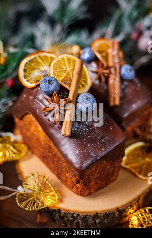 Neujahrskuchen mit zart cremigem Teig und Rosinen, verziert mit Gewürzen, Heidelbeeren und getrockneten Orangenscheiben Stockfoto