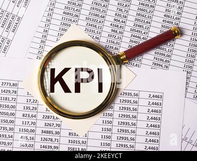 KPI durch Lupe auf Dokumenten mit Zahlen. Stockfoto