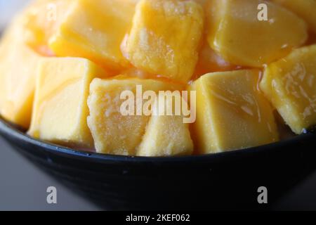 Nahaufnahme des koreanischen Bingsu-Nachtisches mit gefrorenen Mangostückchen Stockfoto