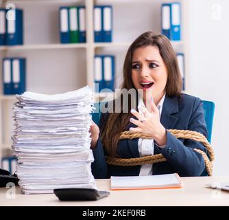 Die junge schöne Mitarbeiter gebunden mit Seil im Büro Stockfoto