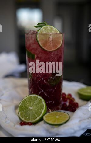 Rotes Cocktailglas mit Passionsfrucht und Wodka, aromatisiert mit Lavendel und zerstoßenem Eis. Stockfoto