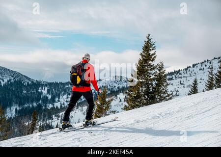 Senior man Skitour auf der Höhe mit Blick auf die Landschaft Stockfoto