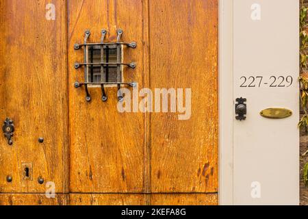 Guckloch, Türklingel und Hausnummern an der alten hölzernen Eingangstür, Utrecht, Niederlande Stockfoto