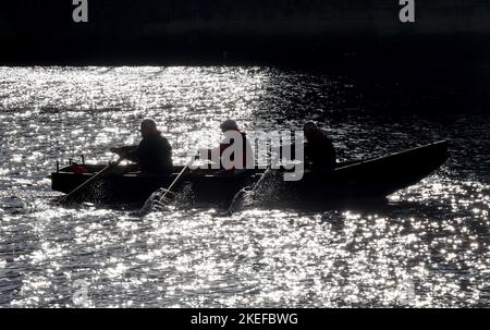 Eine Silhouette einer Currach, während die Crew entlang der Liffey in Dublin ruht. Bilddatum: Samstag, 12. November 2022. Stockfoto