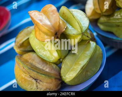 Sternfrüchte, auch bekannt als Averrhoa Carambola, auf einem Teller, der am Stand zum Verkauf angeboten wird Stockfoto