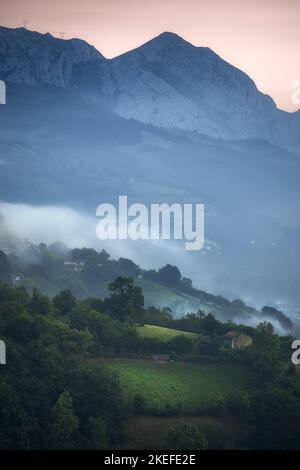 Nebliger und nebliger Morgenblick auf den Berg Monsacro in Asturien Stockfoto