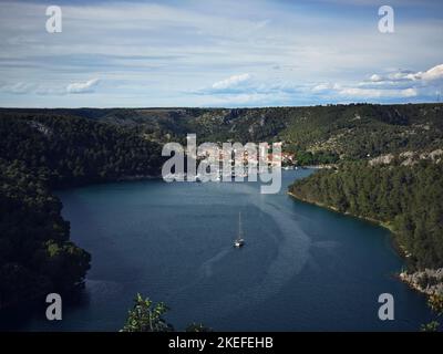 Eine malerische Aussicht auf ein Boot auf dem Fluss Krka und die kleine Stadt Skradin in Kroatien Stockfoto