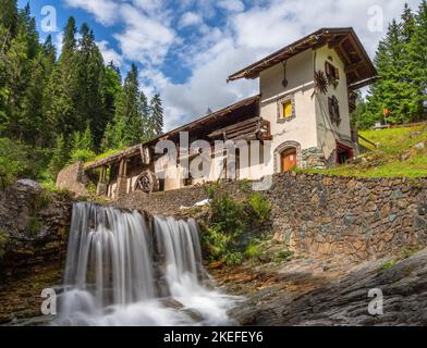 Sappada, Italien - 27. Juli 2022: Idyllisch verlassene Wassermühle in Sappada, einem alpinen Dorf am Rande der italienischen Dolomiten Stockfoto