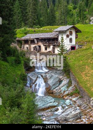 Sappada, Italien - 27. Juli 2022: Idyllisch verlassene Wassermühle in Sappada, einem alpinen Dorf am Rande der italienischen Dolomiten Stockfoto