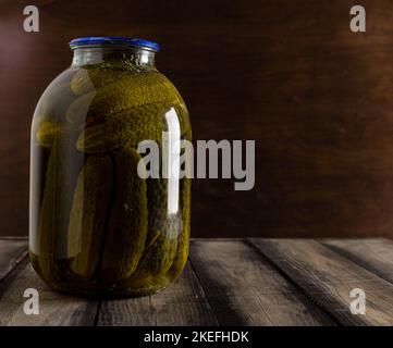 Eingekochte Gurken in Dosen auf einem Holztisch-Hintergrund. Hausgemachte Speisen. Nahaufnahme Stockfoto