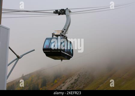 Die Seilbahn beginnt seine Fahrt im nebligen Moleson Stockfoto