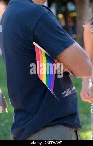 Die Hand des Mannes hält die LGBT-Regenbogenflagge während des Gay Pride, selektiver Fokus, Konzept für die LGBTQ-Gleichheitsbewegung Gemeinschaft Stockfoto