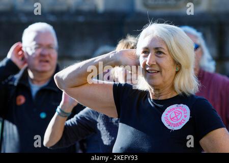 Bath, Großbritannien. 12.. November 2022. Die Demonstranten werden beim Tanz zum Lied „Stayin“ Alive „Bee Gees“ dargestellt, während sie an einem protestmarsch durch das Zentrum von Bath teilnehmen. Der COP 27-Protest in Bath war Teil eines globalen Aktionstages, an dem Menschen aus aller Welt auf die Straße gingen, um die Staats- und Regierungschefs der Welt dazu zu bewegen, bei ihrem Treffen ihrer Verhandlungsführer in Ägypten auf der COP 2022 der UN-Klimakonferenz zu handeln. Quelle: Lynchpics/Alamy Live News Stockfoto