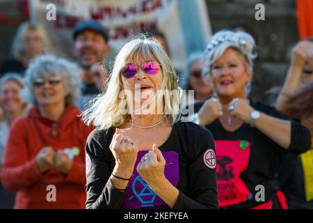 Bath, Großbritannien. 12.. November 2022. Die Demonstranten werden beim Tanz zum Lied „Stayin“ Alive „Bee Gees“ dargestellt, während sie an einem protestmarsch durch das Zentrum von Bath teilnehmen. Der COP 27-Protest in Bath war Teil eines globalen Aktionstages, an dem Menschen aus aller Welt auf die Straße gingen, um die Staats- und Regierungschefs der Welt dazu zu bewegen, bei ihrem Treffen ihrer Verhandlungsführer in Ägypten auf der COP 2022 der UN-Klimakonferenz zu handeln. Quelle: Lynchpics/Alamy Live News Stockfoto