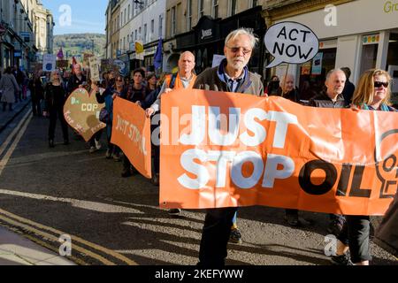 Bath, Großbritannien. 12.. November 2022. Die Demonstranten, die Plakate und Schilder zum Klimawandel tragen, sind abgebildet, während sie an einem protestmarsch zum Klimawandel durch das Zentrum von Bath teilnehmen. Der COP 27-Protest in Bath war Teil eines globalen Aktionstages, an dem Menschen heute weltweit auf die Straße gingen, um die Staats- und Regierungschefs der Welt dazu zu bewegen, beim Treffen ihrer Verhandlungsführer in Ägypten auf der COP 2022 der UN-Klimakonferenz zu handeln. Quelle: Lynchpics/Alamy Live News Stockfoto