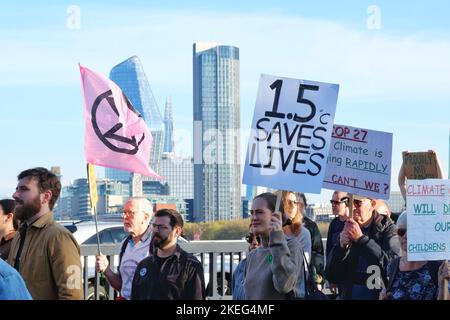 London, Großbritannien. 12.. November 2022. Ein Protestler trägt ein Plakat mit der Aufschrift „1,5c rettet Leben“. Klimaaktivisten verschiedener Organisationen versammelten sich und marschierten, nachdem ägyptische Gruppen auf der Cop 27 zu weltweiten Protesten aufgerufen hatten, um die Ursachen der Klimakrise, Ungerechtigkeiten zu bekämpfen und den Übergang zu erneuerbaren Energien zu fördern. Londoner Aktivisten hoben den Fall des inhaftierten Schriftstellers Alaa Abd El-Fattah und den Tod von Mahsa Amini und Chris Kaba in Polizeigewahrsam hervor. Kredit: Elfte Stunde Fotografie/Alamy Live Nachrichten Stockfoto