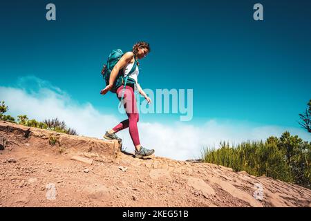 Beschreibung: Wanderer mit Rucksack eine Stufe entlang des Wanderweges auf Pico Ruivo hinunter. Verade do Pico Ruivo, Madeira, Portugal, Europa. Stockfoto