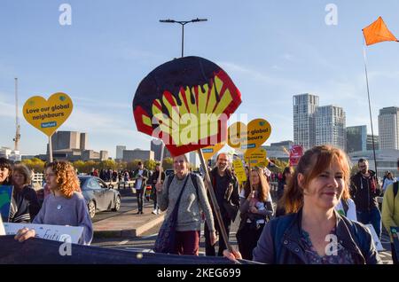 London, Großbritannien. 12.. November 2022. Ein Protestler hält während der Demonstration auf der Waterloo Bridge ein Plakat in Form eines Shell-Logos, das mit Öl bedeckt ist. Tausende von Menschen versammelten sich vor dem Shell-Hauptquartier in London und marschierten zum Trafalgar Square als Teil des Global Day of Action for Climate Justice, als sich die Staats- und Regierungschefs der Welt COP27 in Ägypten trafen. Kredit: SOPA Images Limited/Alamy Live Nachrichten Stockfoto