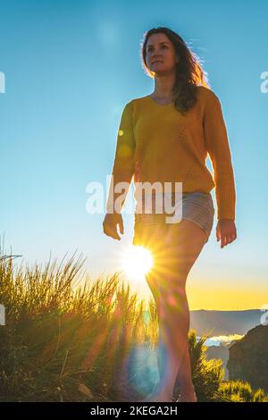 Beschreibung: Sportliche Frau, die barfuß in der Abendsonne auf dem Pico do Ariero auf einem super schönen Wanderweg läuft. Verade do Pico Ruivo, Madeira Stockfoto