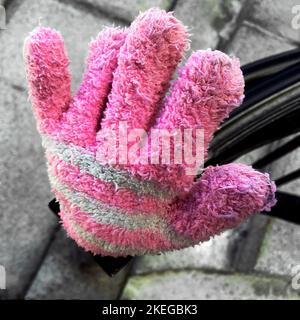 Rosa und weißer Kinderhandschuh auf Zaunpfosten Stockfoto